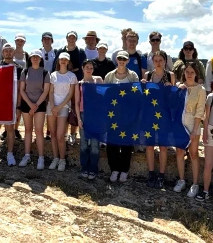 Group photo of the Malta travelers holding a Maltese and European flag