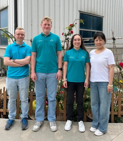 Group photo of the three trainees with a Chinese employee