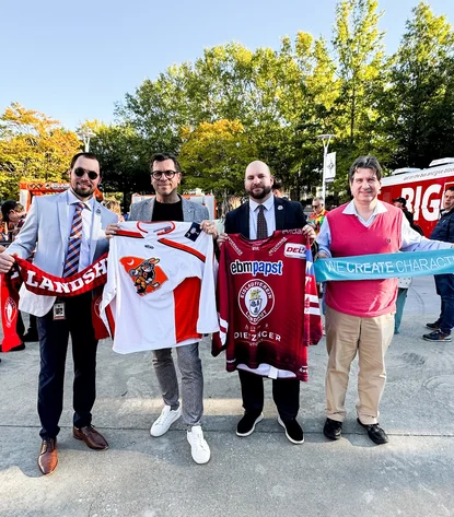 Vorsitzende der Eishockeyvereine halten Trikots und Schals