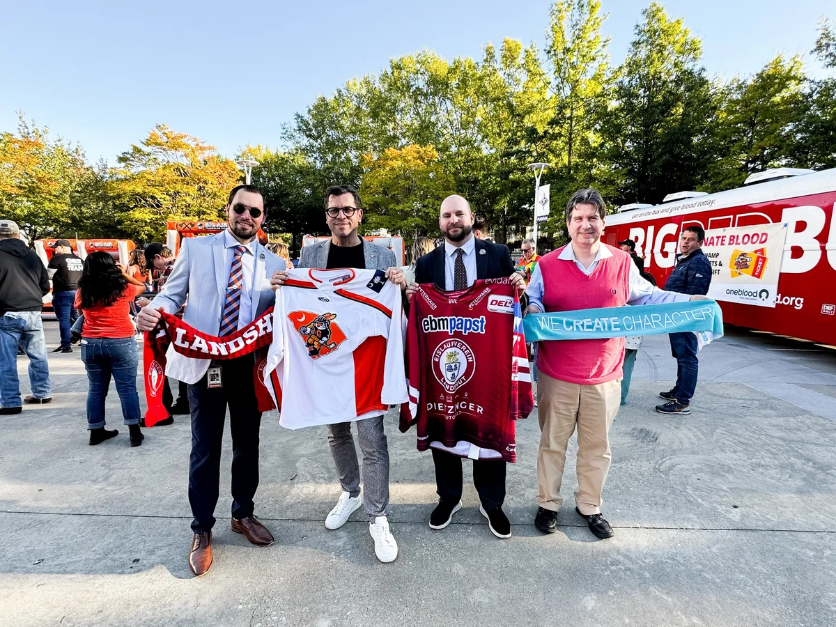 Vorsitzende der Eishockeyvereine halten Trikots und Schals