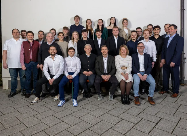 The graduated trainees with the training team as well as Daniel Greifeneder (seated, 3rd from right), head of German training, the works council chairman Rudolf Lang (seated right) and Michael Malec (standing, 2nd from right), responsible for international human resources management.