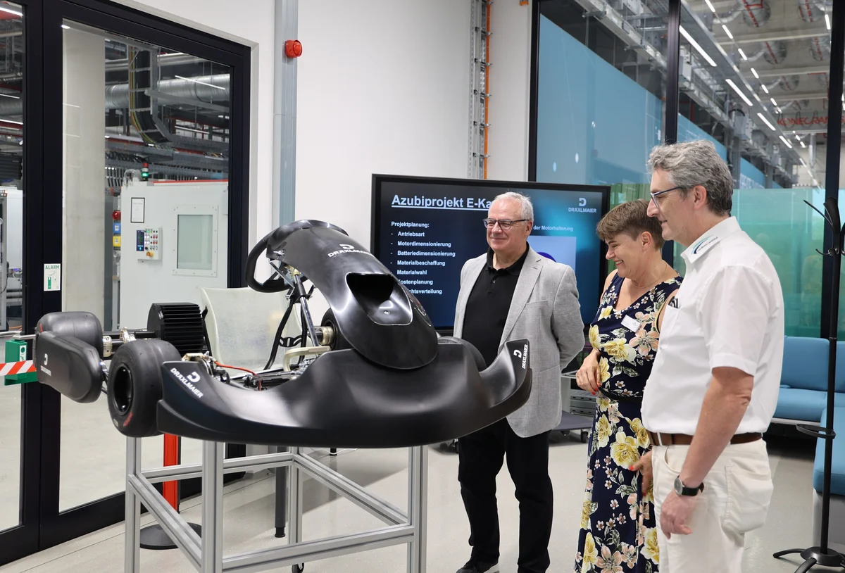 Personalchef Roland Polte, Ausbildungsleiterin Barbara Gerber und Ludwig Götz vom Landkreis Landshut an einem E-Kart, das die Azubis in einem Projekt eigenständig entworfen und gebaut haben.