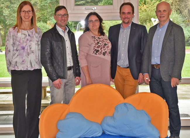 Hinter dem neu angeschafften Kindersofa stehen (von links nach rechts) Betriebsrätin Christine Dittrich, Betriebsratsvorsitzender Rudi Lang, Einrichtungsleiterin Olga Baal, Lebenshilfe-Geschäftsführer Johannes Fauth sowie Tom Wallner, verantwortlich für Spenden und Sponsoring bei DRÄXLMAIER. 