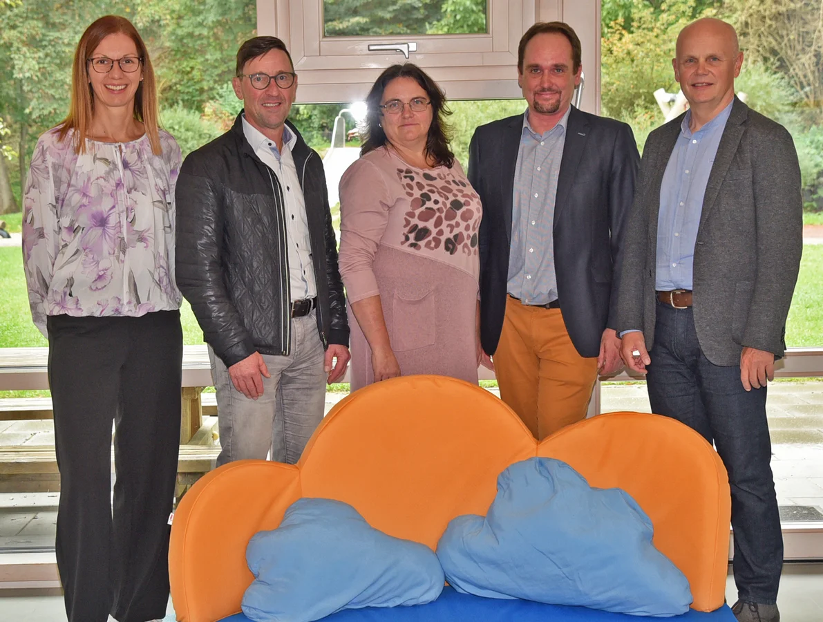 Hinter dem neu angeschafften Kindersofa stehen (von links nach rechts) Betriebsrätin Christine Dittrich, Betriebsratsvorsitzender Rudi Lang, Einrichtungsleiterin Olga Baal, Lebenshilfe-Geschäftsführer Johannes Fauth sowie Tom Wallner, verantwortlich für Spenden und Sponsoring bei DRÄXLMAIER. 