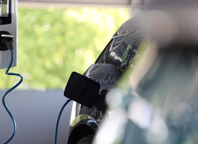 An e-vehicle is connected to an e-charging station. 