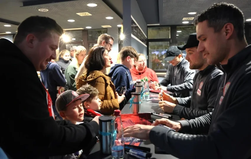 EVL Spieler signieren Autogrammkarten für Fans