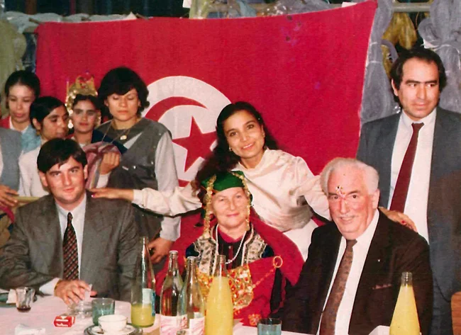 Das Bild zeigt einen Besuch des Standortes Sousse in Tunesien. Die Menschen sitzen an einem Esstisch. 