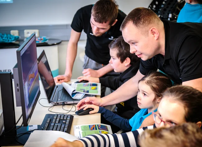Eine Gruppe von Menschen, die an einem Familientag in Jelenia Góra, Polen, teilnimmt. Sie arbeiten an einem Computermodell.
