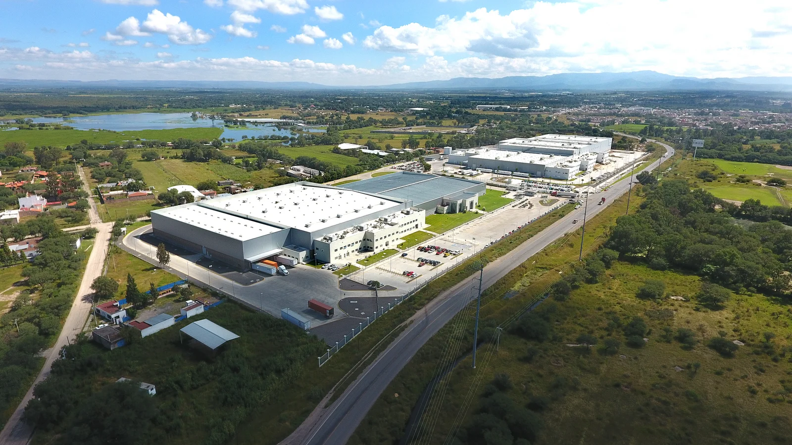 Luftaufnahme eines großen Industriekomplexes mit mehreren Gebäuden in Lagos de Moreno, umgeben von Grünflächen und Straßen.