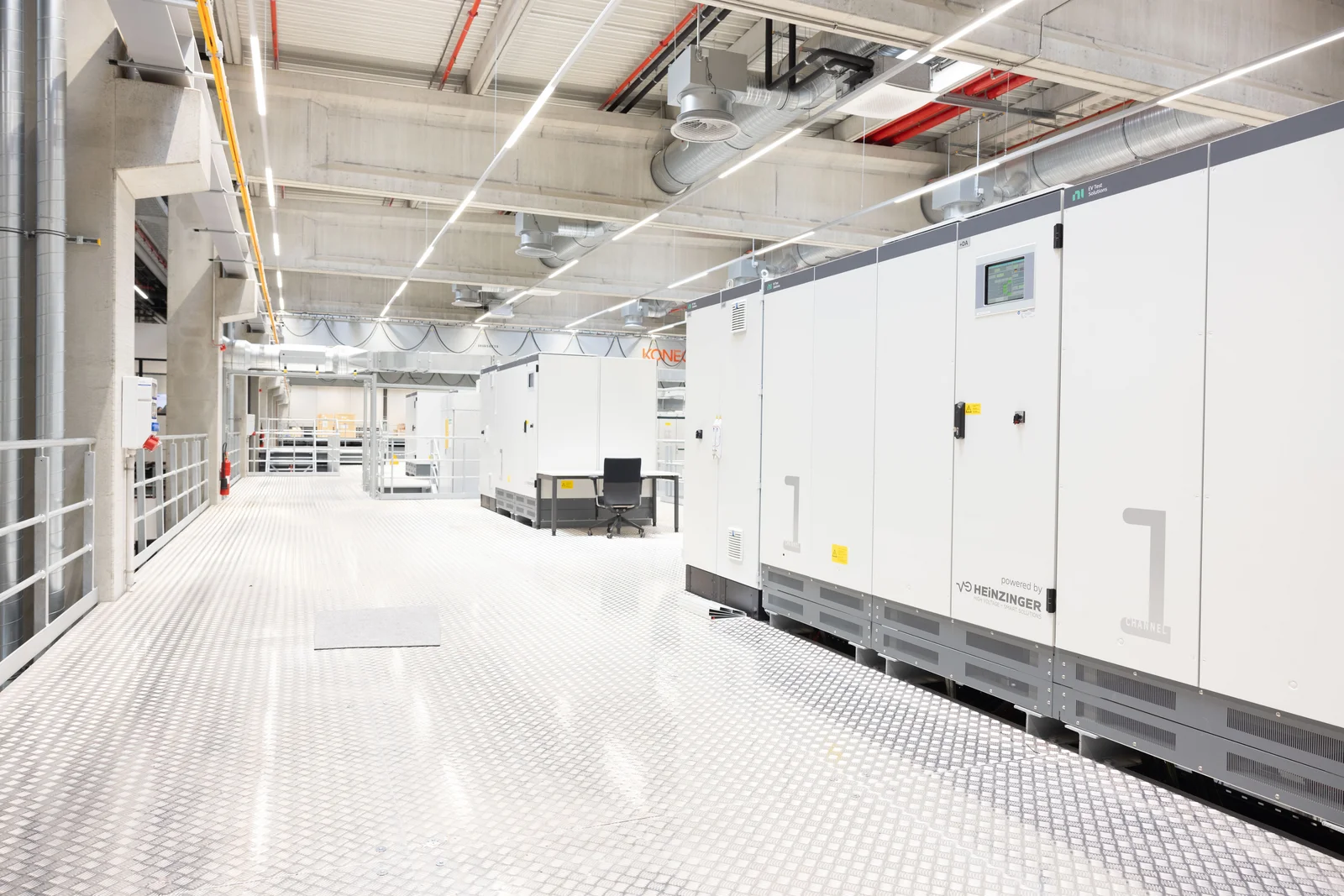 Modern data center with white server cabinets and industrial lighting.