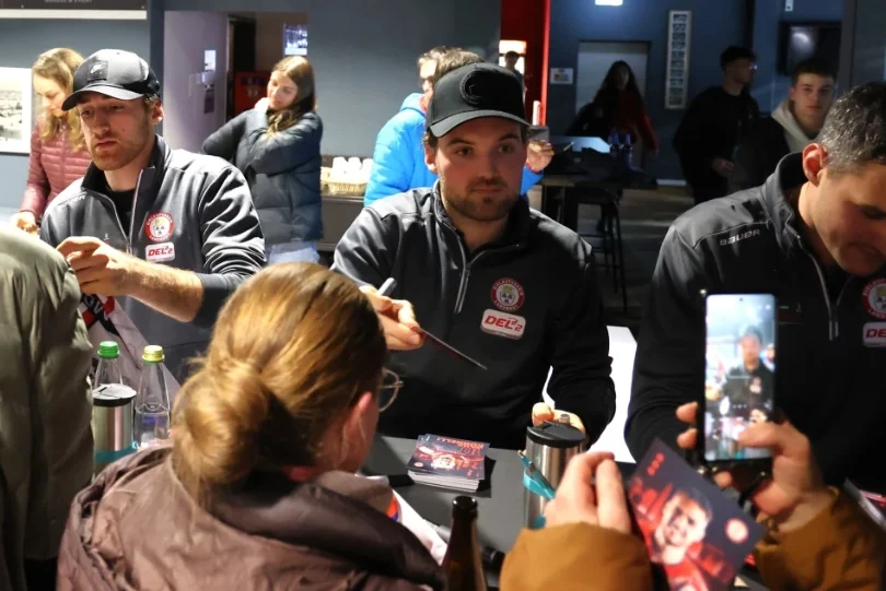 EVL Spieler signieren Autogrammkarten für Fans