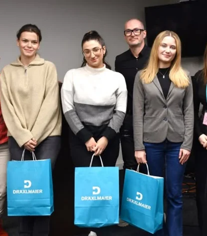Sechs Personen in einer Reihe, drei halten blaue Taschen mit weißem Aufdruck