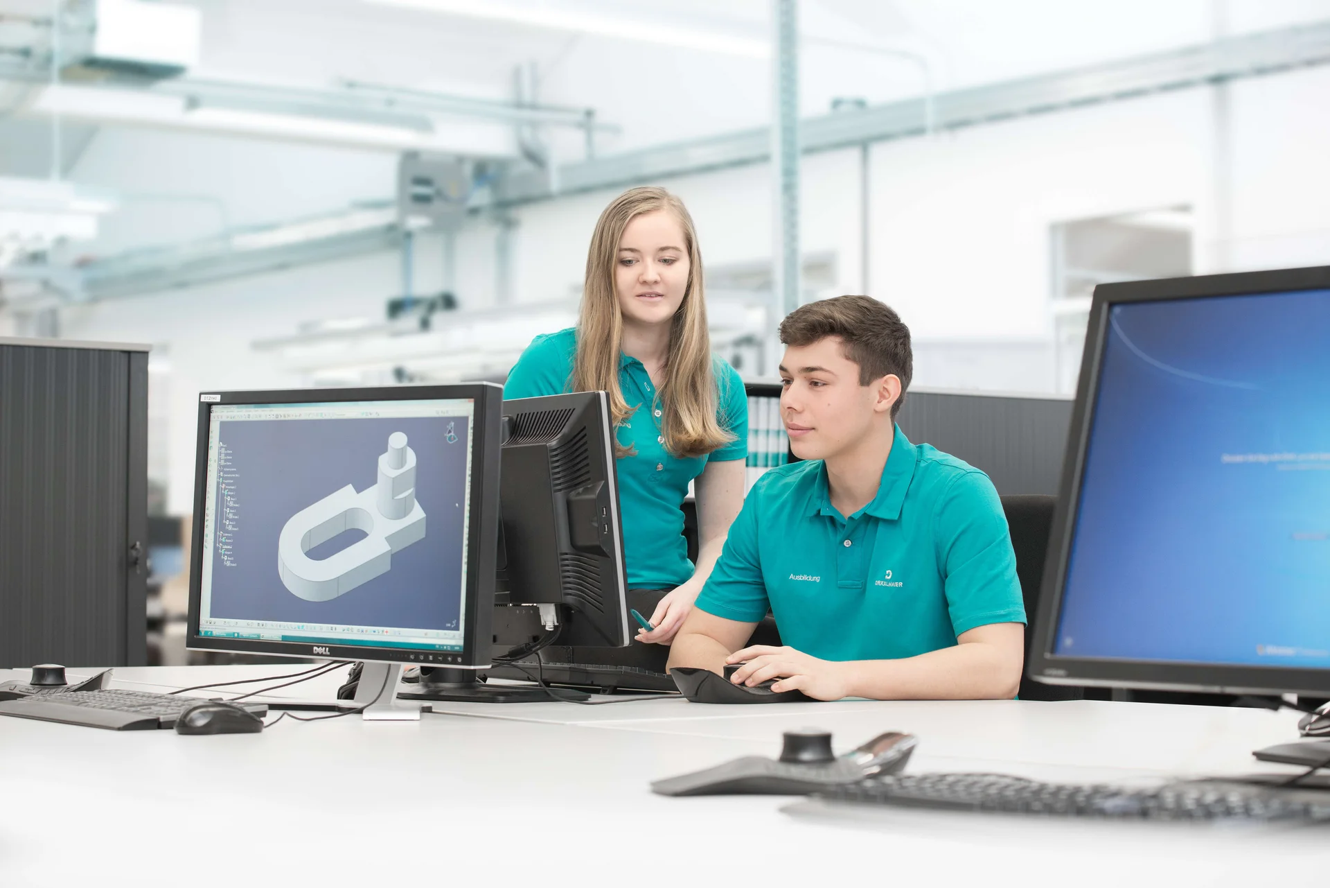 Ein Auszubildender im Produktdesign bei DRÄXLMAIER in Vilsbiburg, der konzentriert an einem Modell am Computer arbeitet.