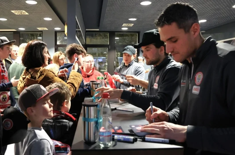 EVL Spieler signieren Autogrammkarten für Fans