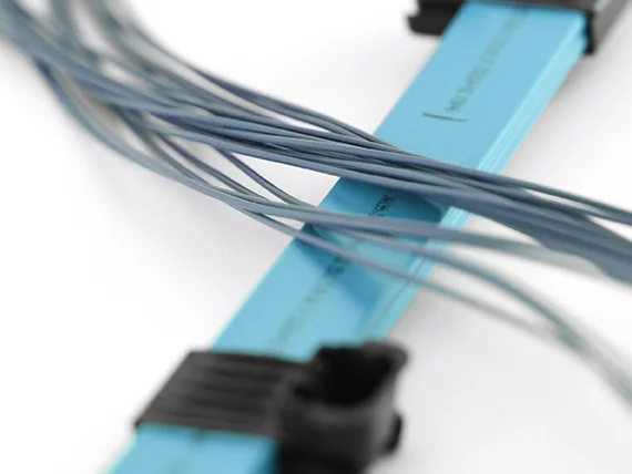 Close-up of blue cables routed through black cable holders.