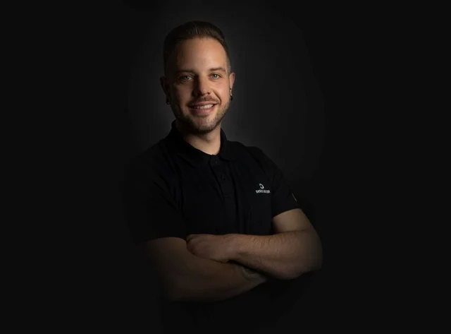 Marc Ein Mann mit verschränkten Armen lächelt in die Kamera.