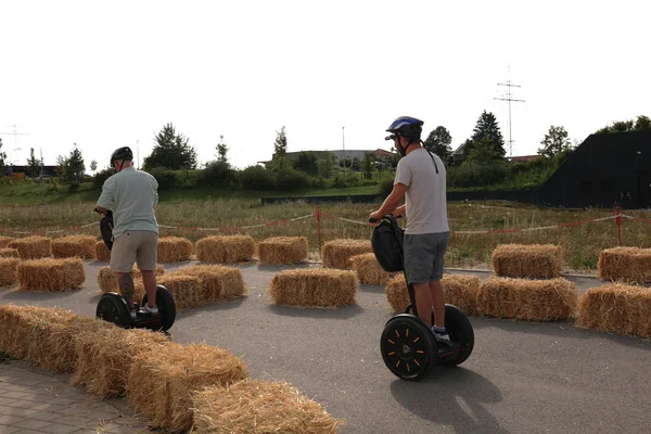 Zwei Besucher fahren mit Segways durch den Parkour