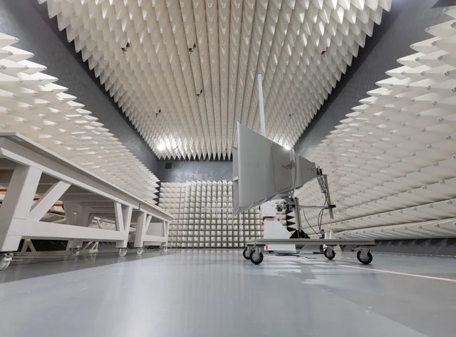 Schalltoter Raum mit pyramidenförmigen Schaumstoffplatten und einem mobilen Gerät mit Antenne.