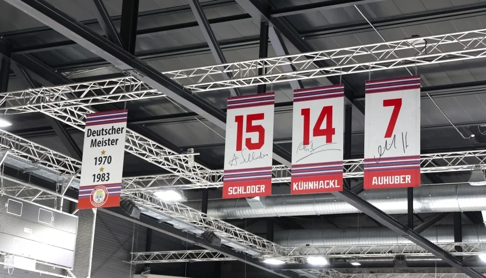 Banner mit Meistertiteln und zurückgezogenen Trikotnummern in einer Eishalle.
